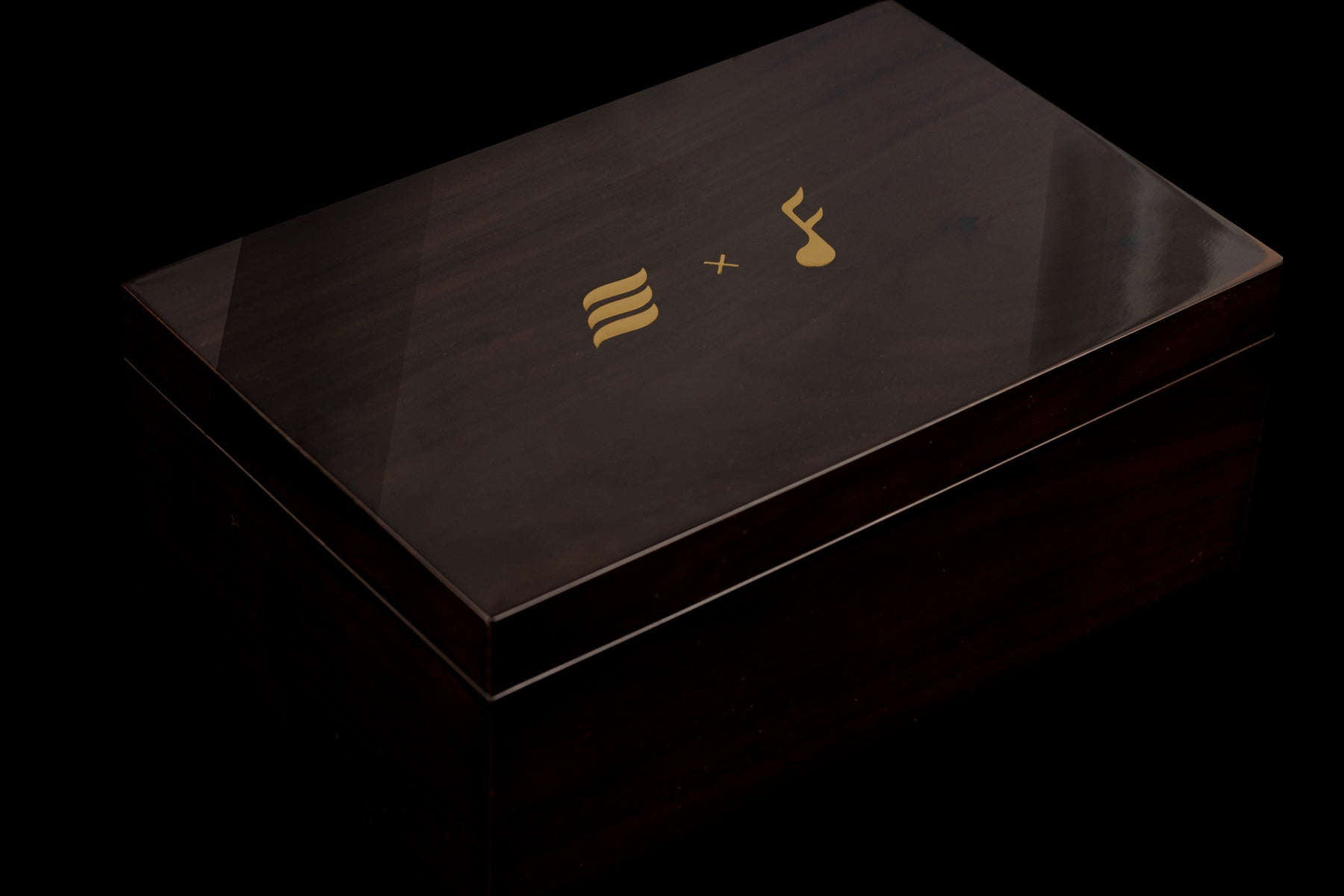 Black rectangular box with gold logo on a black background