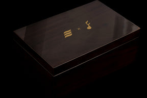 Black rectangular box with gold logo on a black background